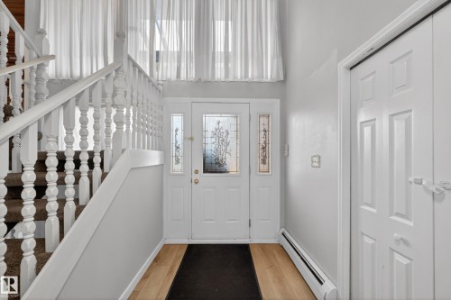 Entryway featuring a white paneled front door with decorative glass inserts and two sidelights - 14808 55 Street, Edmonton, AB 