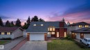 Two-story residence featuring a brick facade with a prominent chimney, large windows, and a two-car garage - 14808 55 Street, Edmonton, AB 