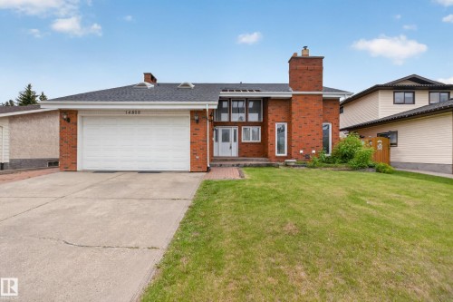 Brick exterior with multi-pane windows and a white double entry door - 14808 55 Street, Edmonton, AB 