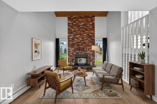 Vaulted ceilings with a prominent brick fireplace feature a wood-burning insert - 14808 55 Street, Edmonton, AB 