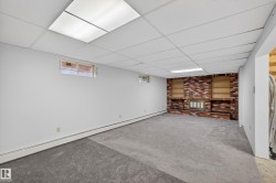 Spacious interior room with light gray carpeting and white painted walls - 