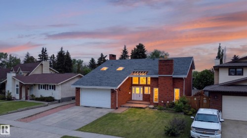 Brick exterior with a prominent chimney and dual white entry doors - 14808 55 Street, Edmonton, AB 