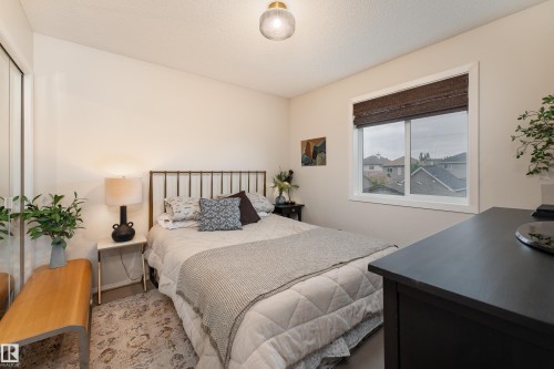 Bedroom featuring soft colour palette, a large window and closet with mirror doors - 5964 South Terwillegar Boulevard, Edmonton, AB 