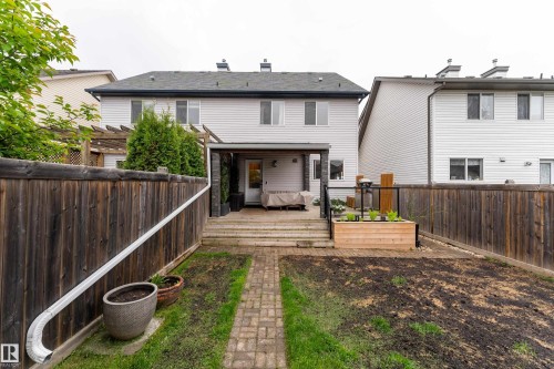 Spacious backyard featuring a multi-level wooden deck with a covered patio area, a built-in planter box, and privacy fencing - 5964 South Terwillegar Boulevard, Edmonton, AB 