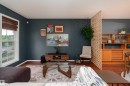 Hardwood-finish flooring extends throughout this living space, complemented by deep-toned walls and crisp white trim - 5964 South Terwillegar Boulevard, Edmonton, AB 