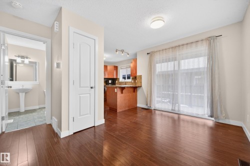 Hardwood-finish flooring throughout, featuring a kitchen with wood cabinetry and granite-finish countertops - 48 8716 179 Avenue, Edmonton, AB 
