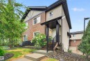 Exterior facade featuring horizontal siding in two tones, a covered entryway with dark railings, and a concrete pathway - 48 8716 179 Avenue, Edmonton, AB 