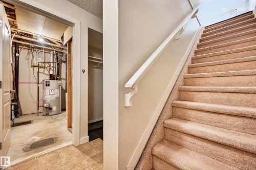 Carpeted staircase with white handrail - 48 8716 179 Avenue, Edmonton, AB 