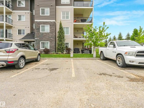 Building exterior featuring balconies with black railings, stone veneer accents, horizontal siding, and multiple windows - 1103 2 Augustine Crescent, Sherwood Park, AB 