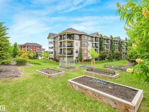 Landscaped grounds featuring multiple raised garden beds, mature trees, and manicured green spaces - 1103 2 Augustine Crescent, Sherwood Park, AB 