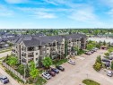 Multi-story building featuring balconies, gabled rooflines, and a dedicated parking area - 1103 2 Augustine Crescent, Sherwood Park, AB 