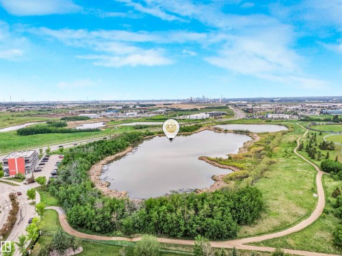 Expansive aerial perspective showcasing a large body of water, surrounded by abundant greenery and walking paths - 1103 2 Augustine Crescent, Sherwood Park, AB 