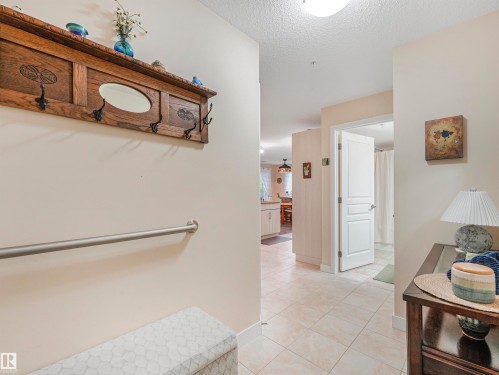 Foyer with square tile flooring, light-toned wall paint, and a white interior door with panel detailing - 1103 2 Augustine Crescent, Sherwood Park, AB 