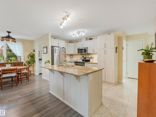 Modern kitchen featuring a central island with a granite countertop and an undermount sink - 1103 2 Augustine Crescent, Sherwood Park, AB 