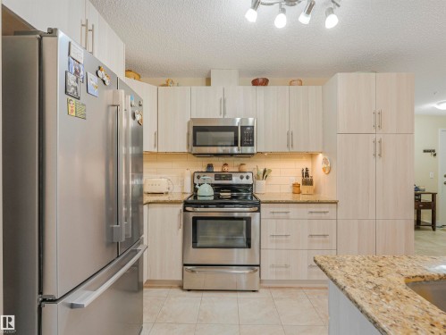 Kitchen featuring extensive light wood-finish cabinetry, stainless steel appliances, granite countertops, and a subway tile backsplash - 1103 2 Augustine Crescent, Sherwood Park, AB 