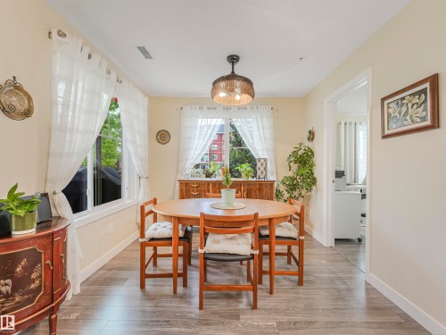Dining area featuring wood-finish flooring, light-toned walls, and a woven pendant light fixture - 1103 2 Augustine Crescent, Sherwood Park, AB 