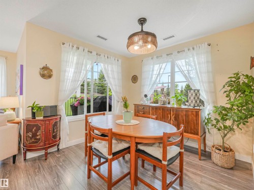Dining area featuring wood-finish flooring and two large windows with natural light - 1103 2 Augustine Crescent, Sherwood Park, AB 