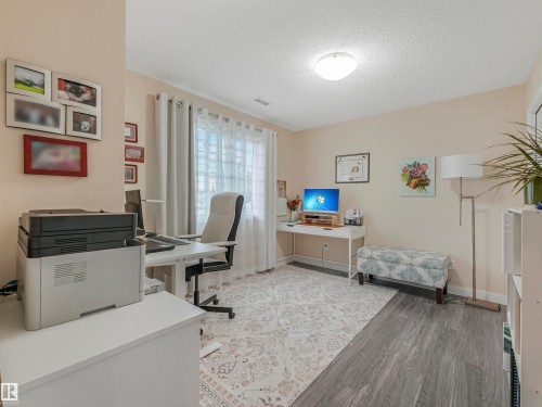 Versatile room featuring a window with privacy blinds, recessed lighting, and a combination of patterned area rug and wood-finish flooring - 1103 2 Augustine Crescent, Sherwood Park, AB 