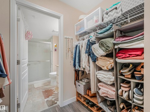 Walk-in closet featuring wire shelving, hanging storage, and wood-finish flooring - 1103 2 Augustine Crescent, Sherwood Park, AB 