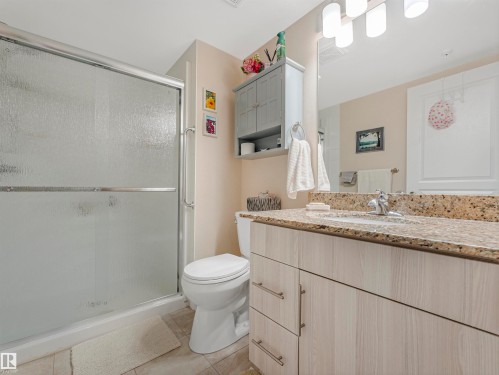 Bathroom featuring a glass-enclosed shower, light-toned wood-finish vanity, speckled countertop, and ceramic tile flooring - 1103 2 Augustine Crescent, Sherwood Park, AB 