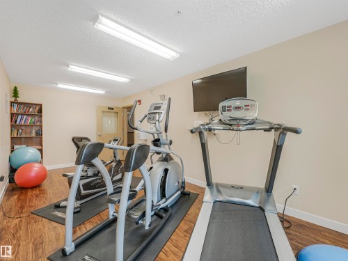 Fitness area featuring wood-finish flooring, recessed lighting, and a wall-mounted television - 1103 2 Augustine Crescent, Sherwood Park, AB 