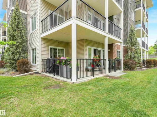 Ground-level patio featuring a black metal railing and direct access to a grassy area - 1103 2 Augustine Crescent, Sherwood Park, AB 