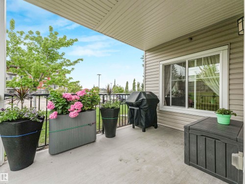 Concrete patio with black metal railings, featuring a sliding window and neutral-toned siding - 1103 2 Augustine Crescent, Sherwood Park, AB 