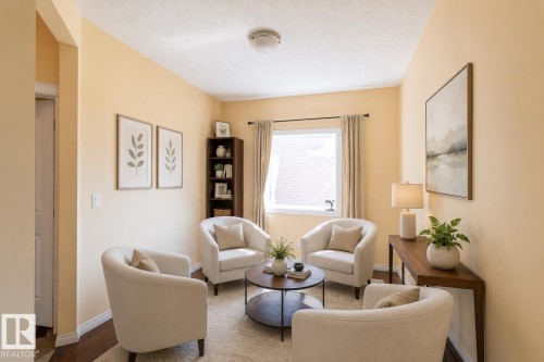 Bright interior space featuring light-toned walls, wood-finish flooring, and a window with blinds and drapes - 1840 56 Street, Edmonton, AB 