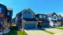Modern two-story home featuring a blue siding exterior, a two-car attached garage, and a concrete driveway - 2120 Muckleplum Crescent, Edmonton, AB 