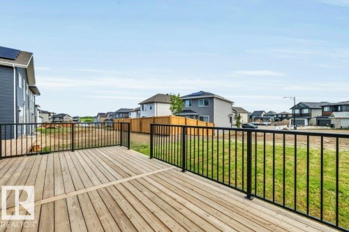 Spacious wood deck with black metal railings, offering an expansive outdoor living area - 13007 213 Street, Edmonton, AB 