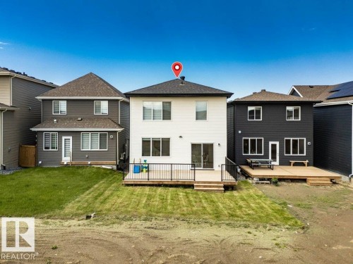 Rear exterior showcasing a spacious deck with black railing and steps to the yard - 13007 213 Street, Edmonton, AB 