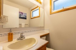 Bathroom vanity with a countertop sink, chrome faucet, and tiled backsplash - 