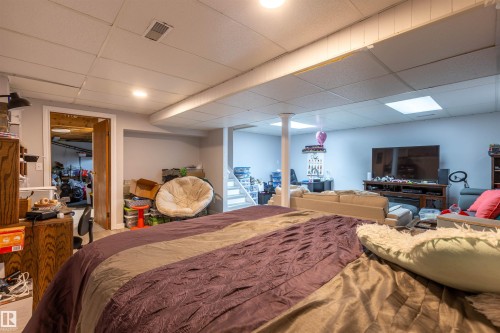 Finished basement area featuring recessed lighting, painted walls, drop ceiling, and a separate room with wood-finish door - 8902 107 Avenue, Morinville, AB 