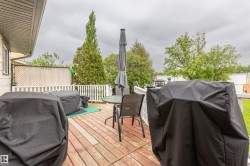 Expansive wood deck with white railing, lattice privacy screen, and exterior wall siding - 