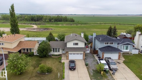 Two-story residence featuring light-colored siding and a contrasting dark shingle roof - 8902 107 Avenue, Morinville, AB 