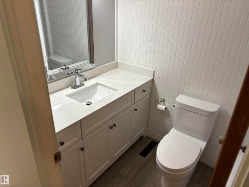 Bathroom vanity featuring a white countertop, undermount sink, and chrome faucet - 51 Glenmore Crescent, St. Albert, AB 
