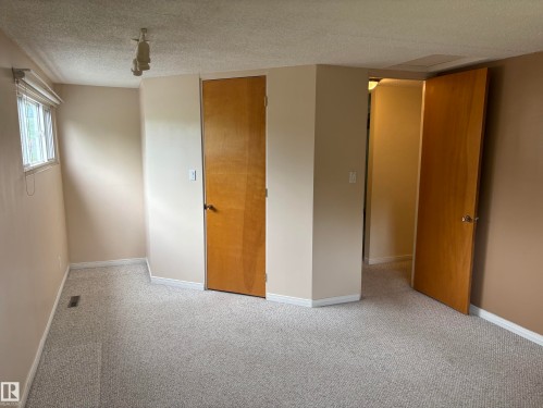 Carpeted room with neutral wall tones and a window featuring horizontal blinds - 51 Glenmore Crescent, St. Albert, AB 