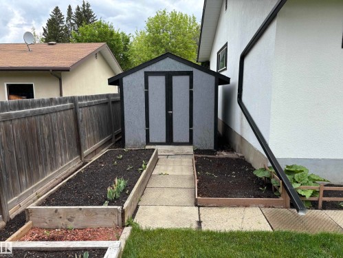 Freestanding shed with double doors, bordered by a wooden privacy fence - 51 Glenmore Crescent, St. Albert, AB 