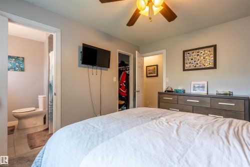 Bedroom featuring a mounted television and a ceiling fan with integrated lighting - 33 Andrew Crescent, St. Albert, AB 