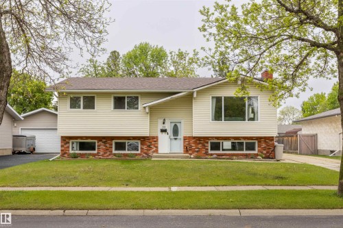 Split-level residence featuring beige horizontal siding and a red brick lower facade - 33 Andrew Crescent, St. Albert, AB 