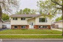 Split-level residence featuring beige horizontal siding and a red brick lower facade - 33 Andrew Crescent, St. Albert, AB 