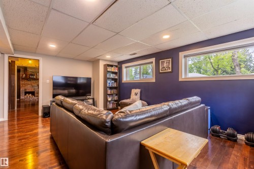 Lower level living area featuring wood-finish flooring, recessed lighting, and two windows - 33 Andrew Crescent, St. Albert, AB 