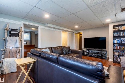 Finished lower level with wood-finish flooring, recessed lighting, and a built-in shelving unit - 33 Andrew Crescent, St. Albert, AB 
