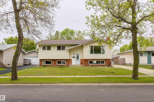 Split-level residence featuring light-colored siding and a brick-finish facade - 33 Andrew Crescent, St. Albert, AB 
