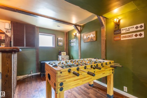 Recreation room featuring exposed wood beams, wood-finish flooring, and built-in bar - 33 Andrew Crescent, St. Albert, AB 