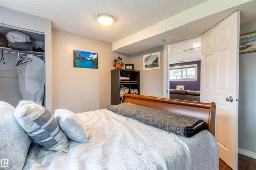 Bedroom featuring light neutral wall paint, a built-in closet with shelving, and overhead lighting - 33 Andrew Crescent, St. Albert, AB 