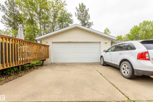 Single-car garage with white panel door and cream-colored siding - 33 Andrew Crescent, St. Albert, AB 