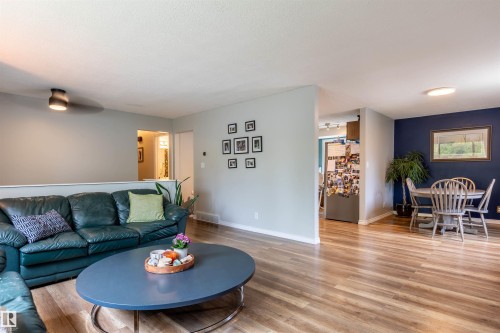 Open concept living area featuring wood-finish flooring and a partial wall dividing spaces - 33 Andrew Crescent, St. Albert, AB 