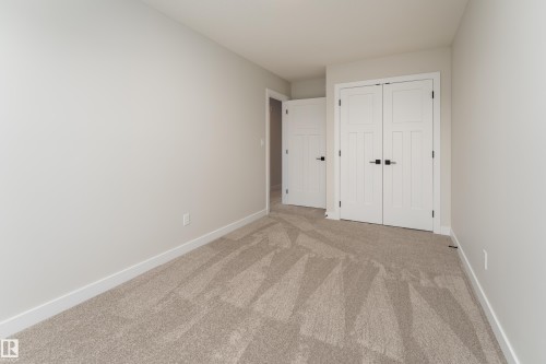 Neutral-toned walls complement the light-colored carpet with geometric patterning - 115 Garneau Gate, Spruce Grove, AB 