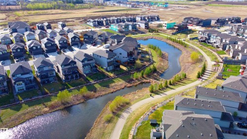 Residential development featuring modern homes with gray and dark gray siding, multiple gables, and attached garages - 115 Garneau Gate, Spruce Grove, AB 
